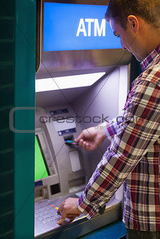 Brunette student withdrawing cash