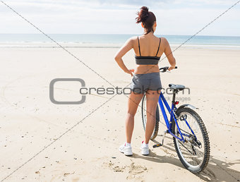 Rear view of a woman with bike on beach
