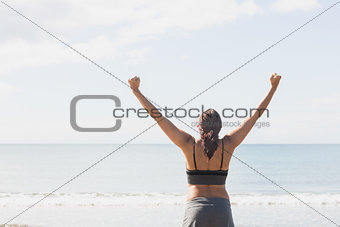 Content brunette woman standing on the beach