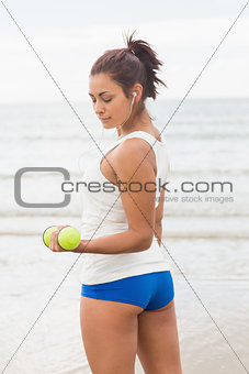 Lovely sporty woman lifting concentrated dumbbells