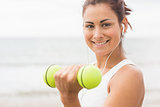 Calm sporty woman lifting dumbbells smiling at camera