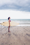 Side view of a woman carrying surfboard on beach