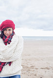 Cute smiling woman in stylish warm clothing on beach