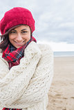 Cute smiling woman in stylish warm clothing on the beach