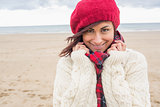 Cute smiling woman in stylish warm clothing on the beach