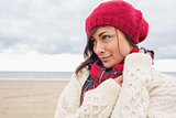 Woman in knitted hat and pullover on the beach