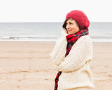 Cute woman in stylish warm clothing at beach