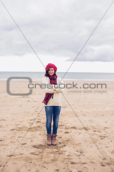 Pretty woman in stylish warm clothing at beach