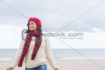 Pretty woman in stylish warm clothing at beach
