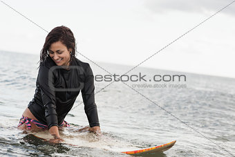 Smiling woman with surfboard in the water