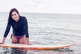 Beautiful young woman with surfboard in water