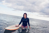 Portrait of a beautiful woman with surfboard in water