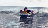 Young woman swimming over surfboard in water