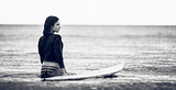 Rear view of a woman with surfboard in water