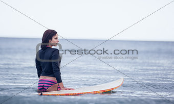 Rear view of a woman with surfboard in water