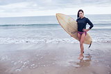 Full length of a woman with surfboard at beach