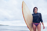 Woman holding surfboard at beach
