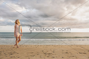 Woman in summer dress walking on beach
