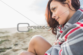 Woman covered with blanket at beach