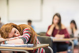 Blurred students in the classroom with one asleep girl