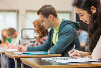 Group of students writing notes in classroom
