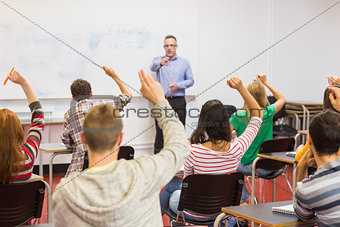 Students raising hands in the classroom