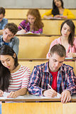 Students sitting at the lecture hall while writing