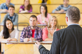 Elegant teacher with students sitting at the lecture hall