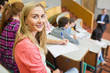 Smiling female with students and teacher at lecture hall