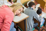 Asleep female with students sitting in lecture hall