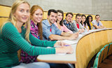 Smiling students sitting in a row at lecture hall
