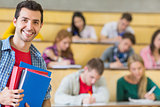 Smiling male with students sitting at the lecture hall