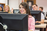 Smiling students using computers in computer room