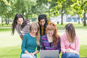 College girls using laptop in the park