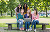Portrait of young college girls with laptop in park