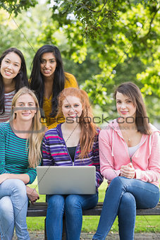 Young college girls with laptop in park