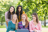 Portrait of college girls with laptop in park