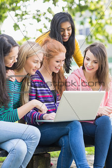 Young college girls using laptop in park