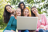 Portrait of college girls using laptop in park