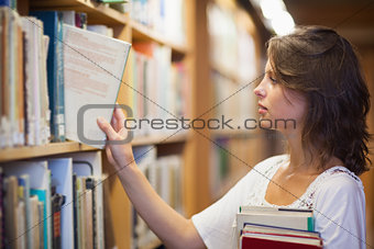 Female student selecting book in the library