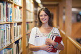 Smiling female student standing in the library