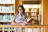Female student with books standing in the library