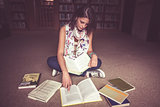 Female student reading a book in library
