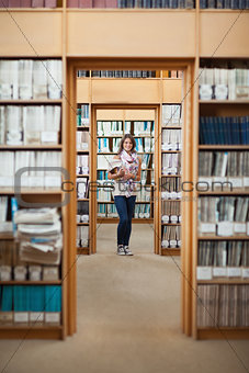 Full lenght of a female student standing in the library