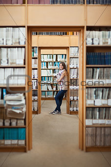 Full length of a female student standing in the library