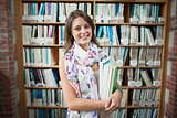 Smiling female student against bookshelf in the library