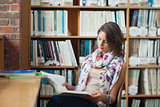 Female student reading a book in the library