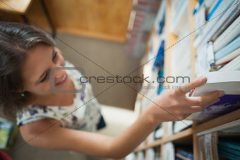 Female student selecting book in the library