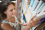 Female student selecting book in library