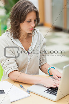 Concentrated female student using laptop